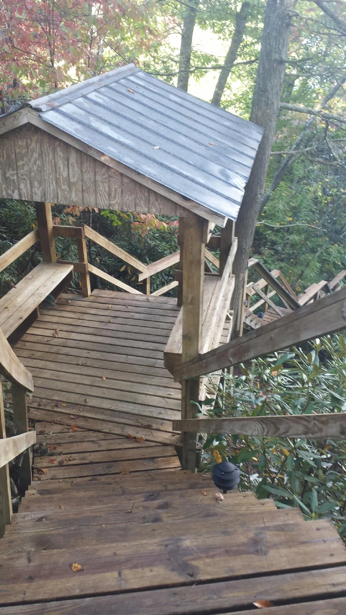 Metal roofed shelter over wooden steps on a wooded walkway — Skylight Repair & Installation work by our crew in Plymouth