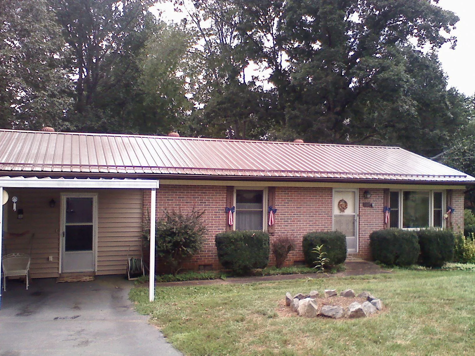 Bronze metal roof and carport on a brick ranch home — Roof Repair work by our crew in Plymouth